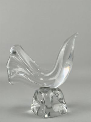 une sculpture en verre représentant un oiseau posé sur un socle