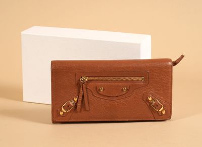 a brown leather purse sitting next to a white box