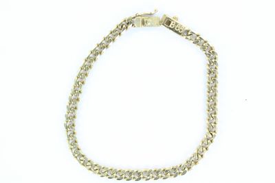 gros plan d'un bracelet en chaîne en or sur fond blanc