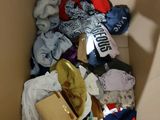 a cardboard box filled with clothes and other items