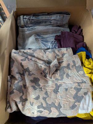 une boîte pleine de vêtements posée sur le sol