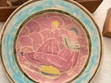 une assiette avec une peinture posée sur une table