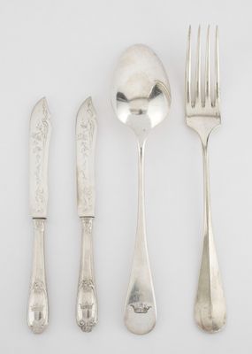 four forks, a spoon, and a knife on a white surface