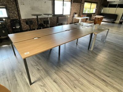 des tables et des chaises dans une pièce où se trouve un tableau blanc accroché au mur