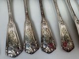 five spoons that are lined up on a table