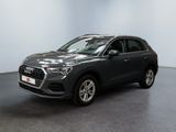 une Audi QX grise garée dans une grande pièce