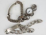 a silver watch and a chain on a white surface
