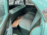 a green car with a blue seat and a black seat cover