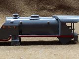 three toy trains sitting side by side on the ground