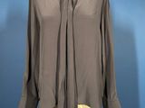 grey shirt with tie on mannequin dummy against blue background