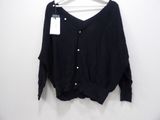 the black sweater is hanging on a hanger on a white wall