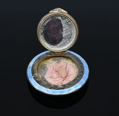 Petit poudrier rond en argent (800‰) ciselé, à décor émaillé…