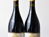 deux bouteilles de vin rouge posées sur une table en bois