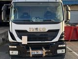 un camion blanc garé sur un parking à côté d'un immeuble