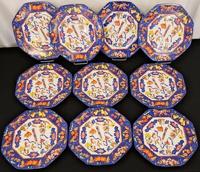 six blue and orange plates with designs on them sitting on a table