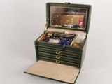 une petite boîte verte contenant de nombreux objets