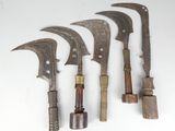 several old knives are lined up on a white surface