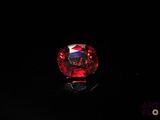 a close up of a red diamond on a black surface