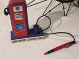 a small red and blue gas pump with a red pen on it