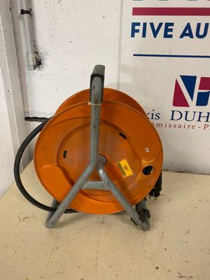 un casque de chantier orange posé sur le sol, à côté d'un panneau
