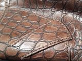 crocodile skin pattern on a leather purse with a zipper