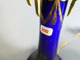 a blue vase with a gold decoration on it