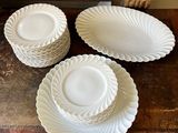 quatre assiettes et bols blancs posés sur une table en bois