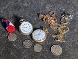 a lot of coins and a pocket watch on a table