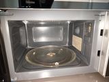 un micro-ondes posé sur un plan de travail, avec une casserole à l'intérieur