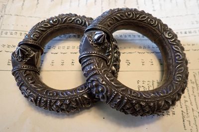 deux bracelets en argent posés sur une feuille de papier
