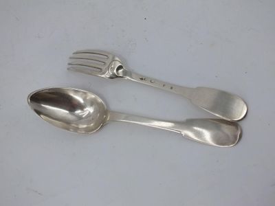 two spoons and a fork sitting on a table