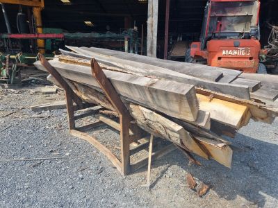 un tas de bois posé par terre à côté d'un chariot élévateur