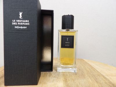 perfume bottle in a black box sitting on a table next to a black box
