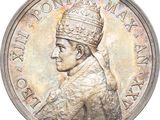 l'image d'une pièce d'argent sur laquelle figure le portrait d'un homme coiffé d'une couronne