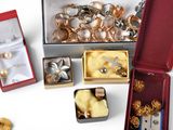 a lot of gold and silver jewelry in a red box