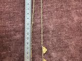 a close up of a gold necklace with a chain attached to it