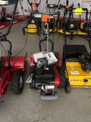 Plusieurs tondeuses à gazon sont alignées en rang dans un garage
