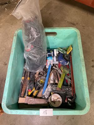 a plastic container filled with assorted tools on the floor