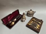 des couverts en argent rangés dans un coffret posé sur une table