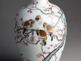 un vase blanc orné d'une peinture représentant des oiseaux et des fleurs