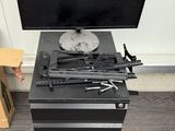 a tv on top of a black cabinet with guns on it