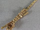 a close up of a gold saxophone on a gray cloth