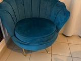 une chaise bleue qui se trouve dans un coin de la pièce