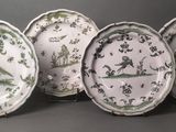 six plates with green and white designs on them sitting on a table