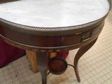 a small table with a marble top on a tile floor