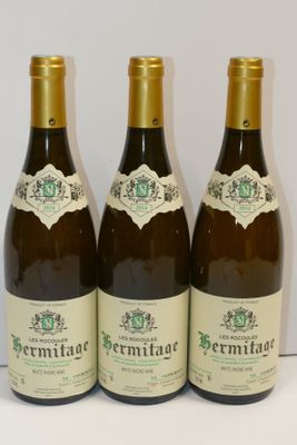 trois bouteilles de vin posées sur une table, l'une à côté de l'autre