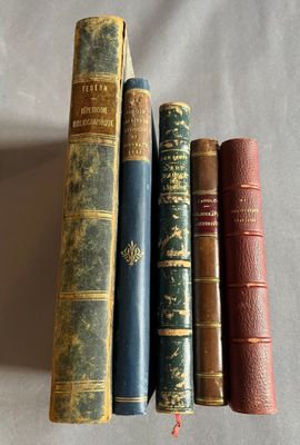 quatre vieux livres alignés les uns à côté des autres sur une surface blanche