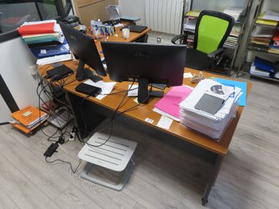 un bureau sur lequel sont posés deux écrans et un ordinateur portable
