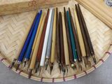 a lot of pens sitting in a basket on a table