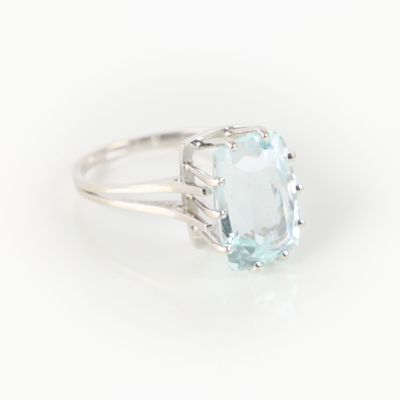 a close up of a ring with a blue topaz stone in it